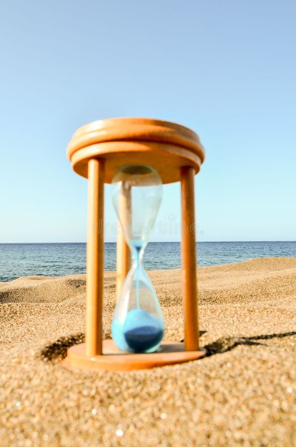 Timglasklocka på sandstranden fotografering för bildbyråer