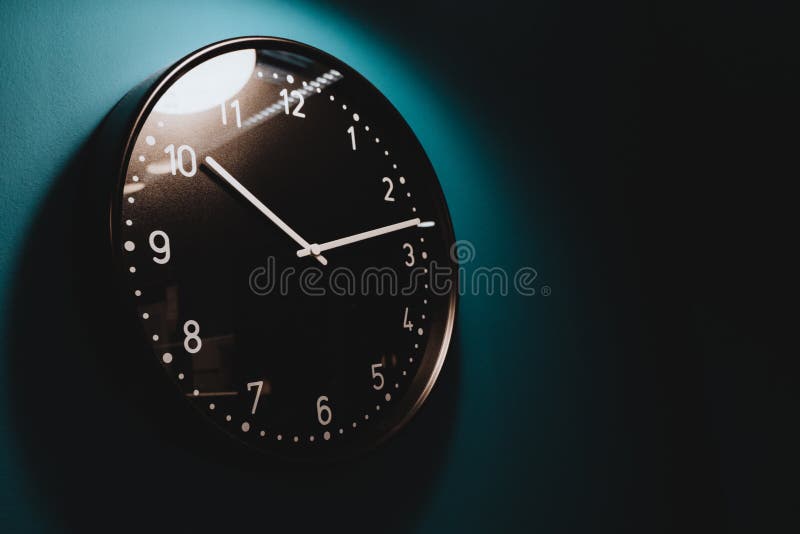 Timing concept in home black clock hand on dark wall