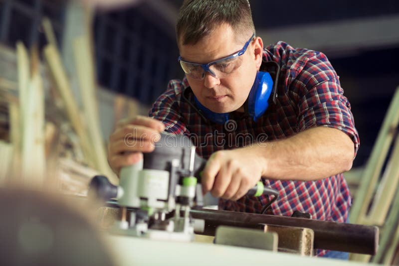 Timmerman met een elektrische router royalty-vrije stock afbeeldingen Timmerman met een elektrische router royalty-vrije stock afbeeldingen