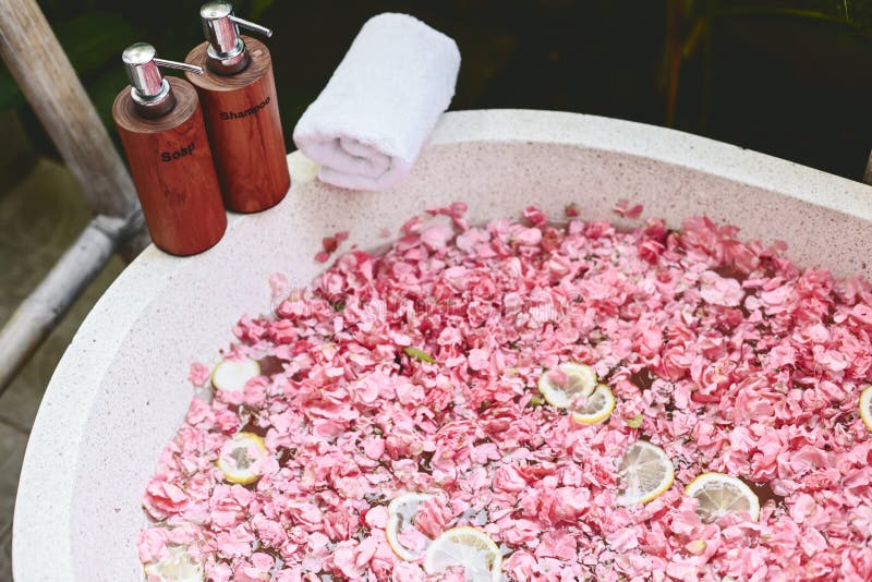 Tina de baño con los pétalos de la flor, la toalla y los productos de belleza imagenes de archivo Tina de baño con los pétalos de la flor, la toalla y los productos de belleza imagenes de archivo