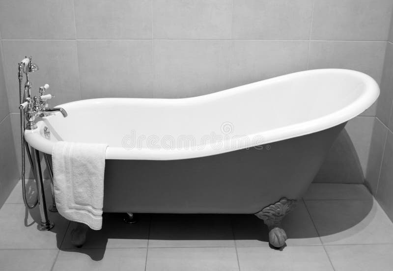 Old style bath tub with metal legs and towel, vintage style on b&w tone. Old style bath tub with metal legs and towel, vintage style on b&w tone