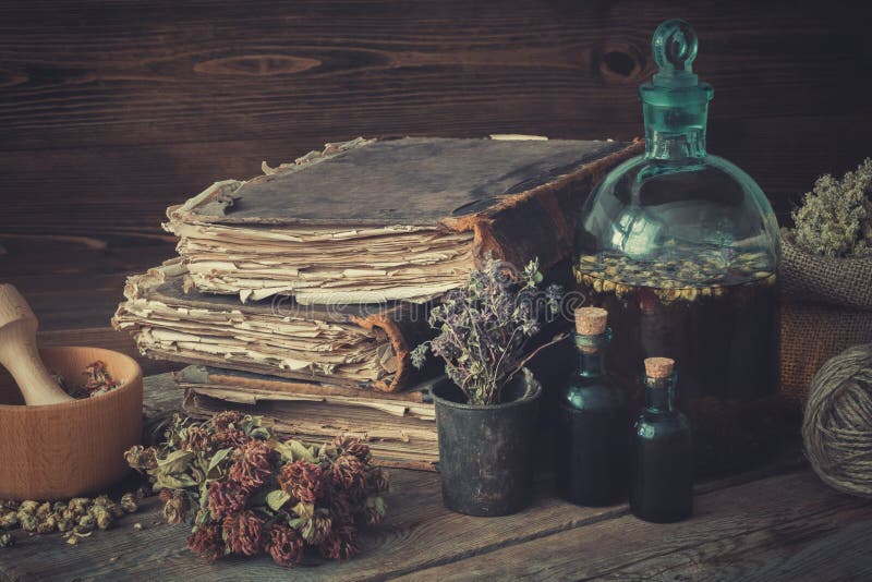 Tincture bottles, assortment of dried healthy herbs, old books, wooden mortar, sack of medicinal herbs. Herbal medicine. stock photos Tincture bottles, assortment of dried healthy herbs, old books, wooden mortar, sack of medicinal herbs. Herbal medicine. stock photos