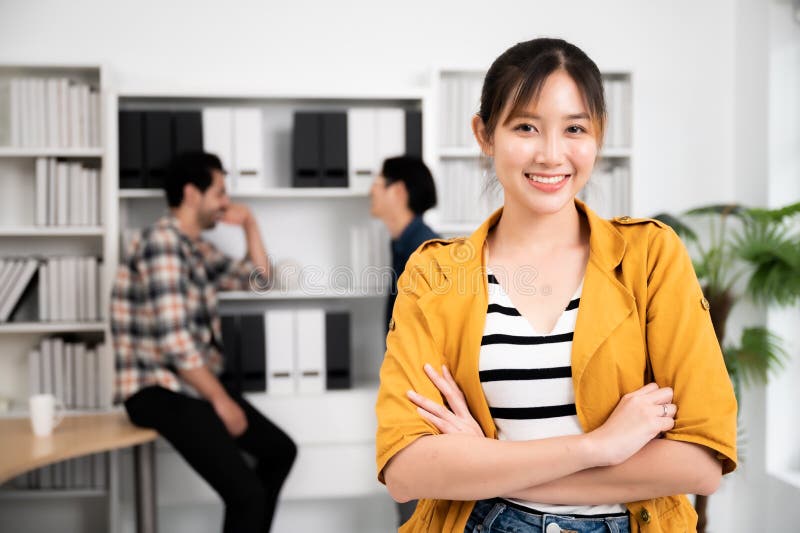 Tinere femei asiatice care au început o cameră pentru afaceri cu zâmbet larg stock image