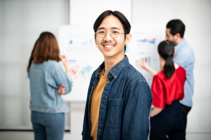 Tineri asiatici, lideri ai echipei de încredere în afaceri, care privesc camera și zâmbesc royalty free stock photo