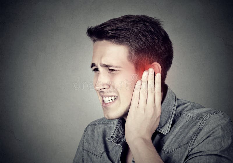 tinnitus Homem doente que tem a dor de orelha que toca em sua cabeça dolorosa