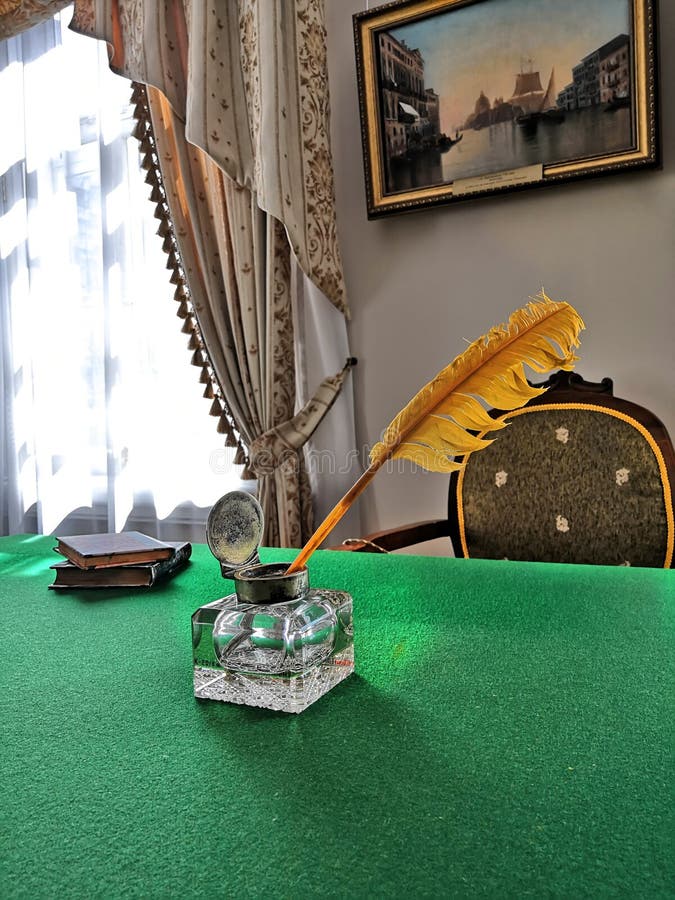 Tintero viejo con una pluma en la tabla fotografía de archivo Tintero viejo con una pluma en la tabla fotografía de archivo