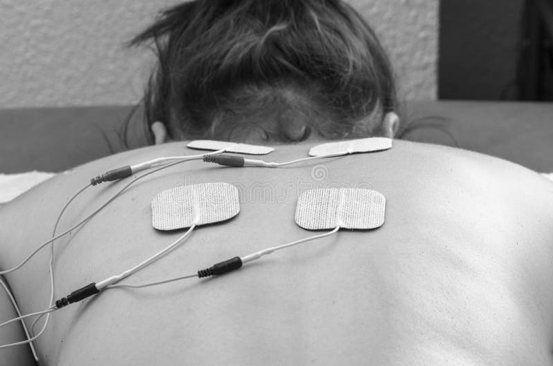 TIOelektroder som placeras för tillbaka, smärtar behandling i läkarundersökning t arkivfoton TIOelektroder som placeras för tillbaka, smärtar behandling i läkarundersökning t arkivfoton