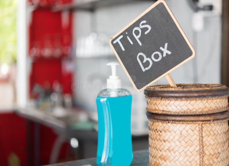 Tip Box and Hand Sanitizer on Table in Restaurant Stock Photo Image