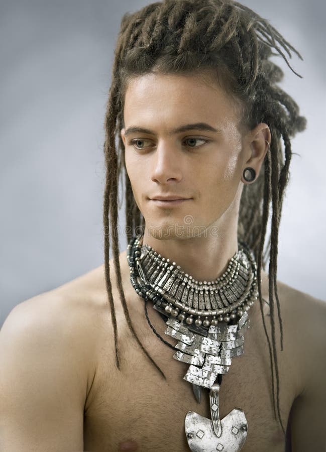 Tipo bello con i dreadlocks ed i gioielli fotografie stock Tipo bello con i dreadlocks ed i gioielli fotografie stock