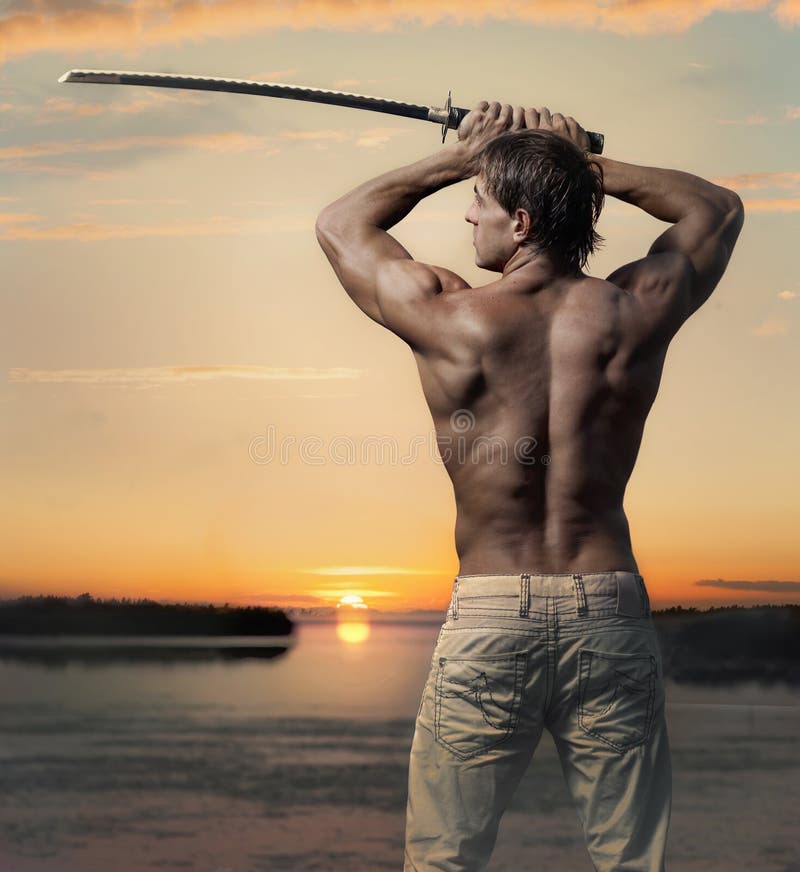 Tipo bello muscolare con la spada al tramonto immagine stock libera da diritti Tipo bello muscolare con la spada al tramonto immagine stock libera da diritti