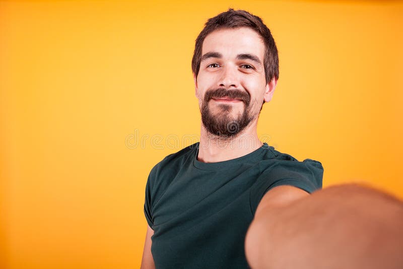 Tipo bello sorridente fresco che sorride alla macchina fotografica mentre prendendo un selfie fotografie stock libere da diritti Tipo bello sorridente fresco che sorride alla macchina fotografica mentre prendendo un selfie fotografie stock libere da diritti