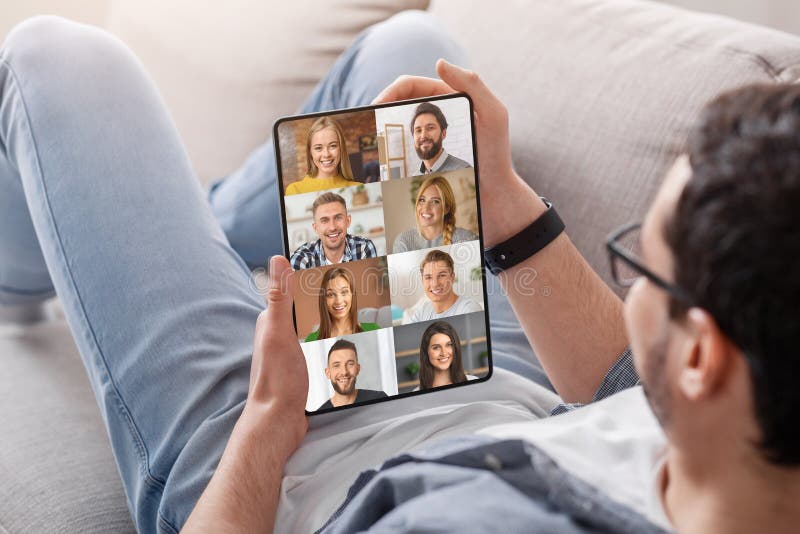Tipo irreconocible con tablet digital con videollamadas grupales con amigos imagen de archivo libre de regalías