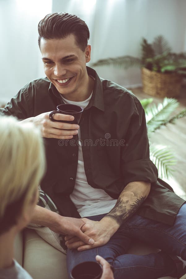 Tipo sorridente che esamina ragazzo e tenuta della sua mano fotografie stock libere da diritti Tipo sorridente che esamina ragazzo e tenuta della sua mano fotografie stock libere da diritti