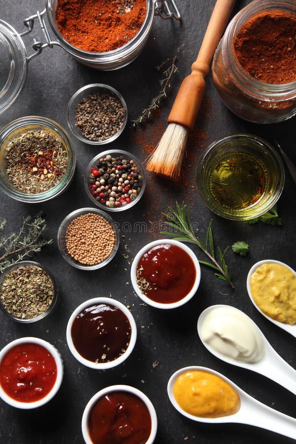 Close up Assorted Seed Type Spices and Sauces on Containers Placed on Top of the slate Table. Close up Assorted Seed Type Spices and Sauces on Containers Placed on Top of the slate Table