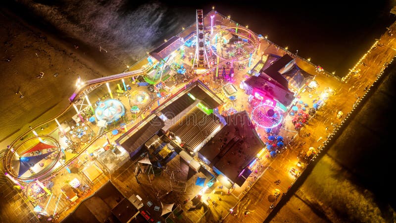 Tir aérien d'un carnaval à un parc d'attraction près de la plage la nuit photos libres de droits Tir aérien d'un carnaval à un parc d'attraction près de la plage la nuit photos libres de droits