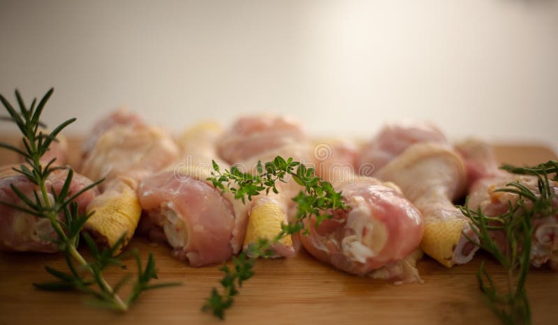 Tir brouillé de poulet sur une planche à découper avec le romarin frais a images stock Tir brouillé de poulet sur une planche à découper avec le romarin frais a images stock