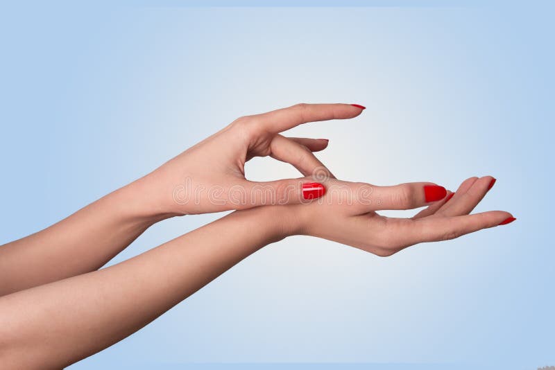 Conceptual shot of beautiful woman`s hand with manicure red nail polish isolated on blue background. Conceptual shot of beautiful woman`s hand with manicure red nail polish isolated on blue background