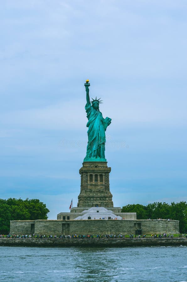 Tir cultivé de statue de la liberté avec l'eau et le ciel photos stock Tir cultivé de statue de la liberté avec l'eau et le ciel photos stock