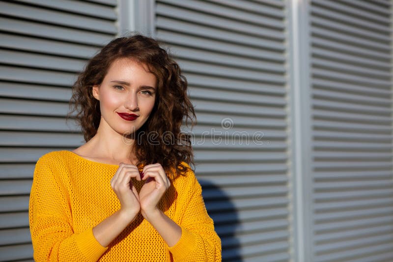 Tir de mode de vie : belle fille de brune dans le chandail tricoté jaune m image stock Tir de mode de vie : belle fille de brune dans le chandail tricoté jaune m image stock