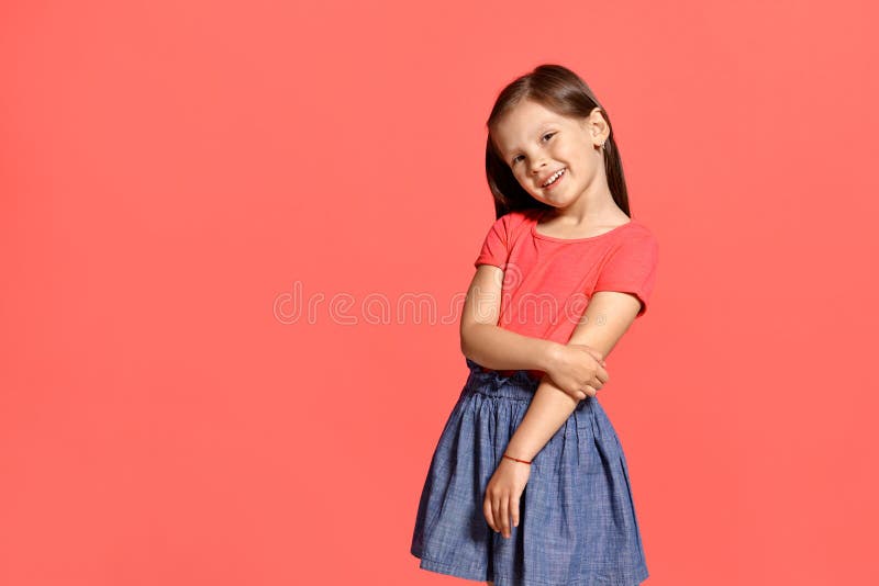 Tir en gros plan de studio de la petite fille de belle brune posant sur un fond bleu image stock Tir en gros plan de studio de la petite fille de belle brune posant sur un fond bleu image stock