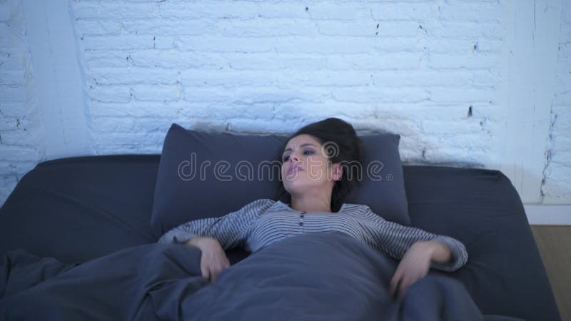Tir frontal de jeune renversement hispanique attrayant de femme dans le mensonge d'effort et d'insomnie soucieux sur le lit et l' clips vidéos