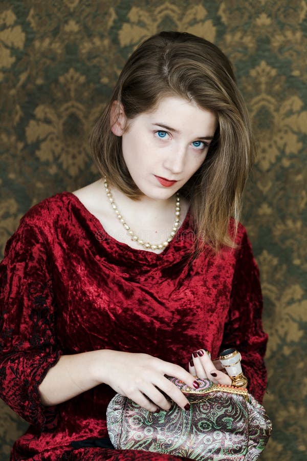 Tir moyen vertical de pâle exquis - jeune femme aux yeux bleus portant la robe rouge de velours image stock Tir moyen vertical de pâle exquis - jeune femme aux yeux bleus portant la robe rouge de velours image stock