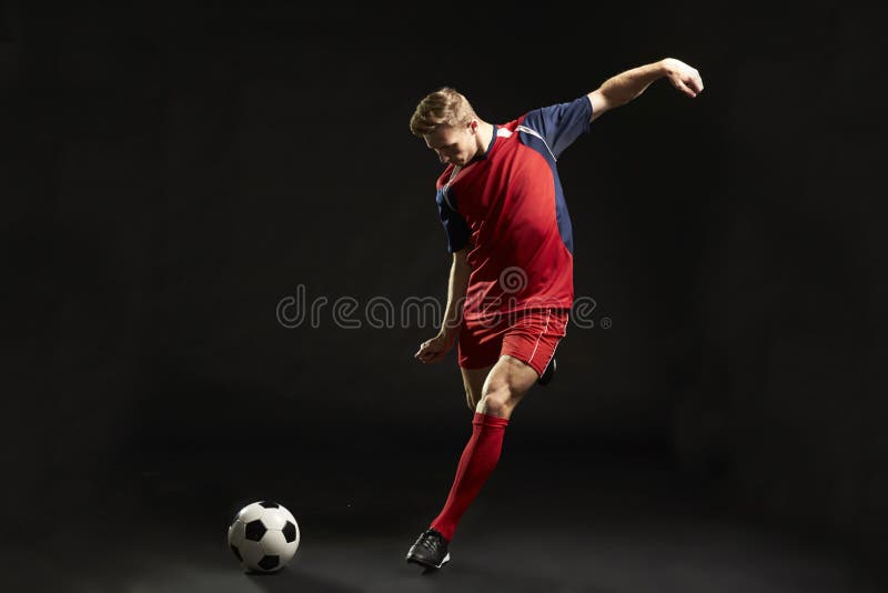 Tir professionnel de footballeur au but dans le studio photo stock