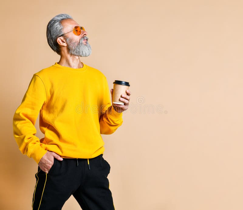 Tir vertical d'un a?n? joyeux tenant une tasse de caf? blanc et regardant la cam?ra image stock Tir vertical d'un a?n? joyeux tenant une tasse de caf? blanc et regardant la cam?ra image stock