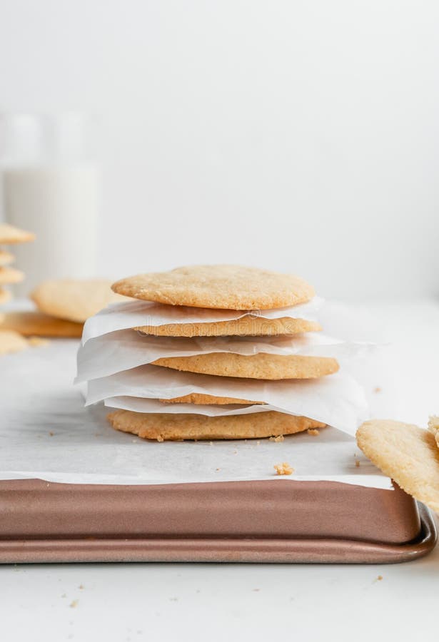 Tir vertical d'une pile de biscuits maison avec des serviettes blanches sur un plateau