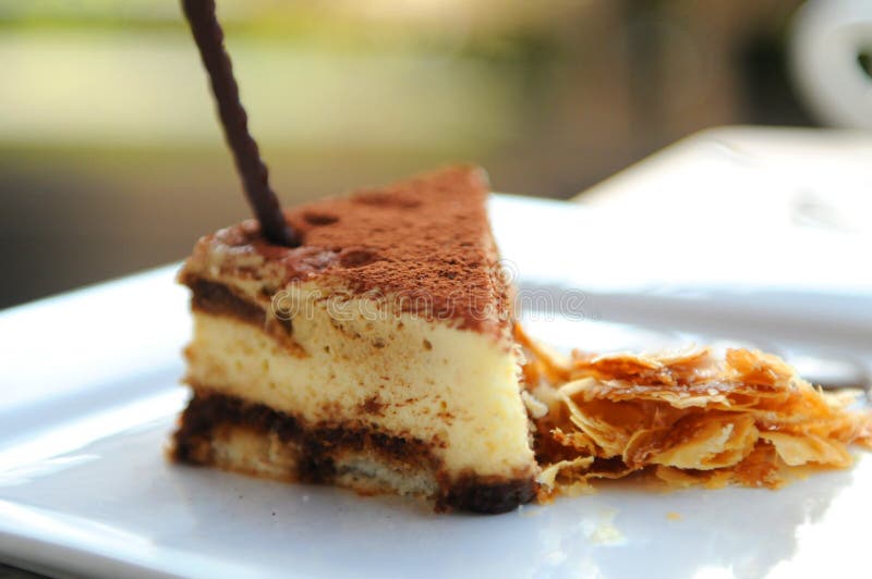 Tiramisu, an Italian dessert consisting of layers of sponge cake soaked with coffee and liqueur layered with mascarpone cheese and topped with grate chocolate. Tiramisu, an Italian dessert consisting of layers of sponge cake soaked with coffee and liqueur layered with mascarpone cheese and topped with grate chocolate.