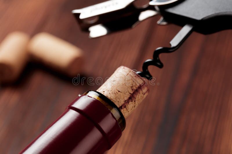 Tire-bouchon et bouteille de vin sur le conseil - image photographie stock Tire-bouchon et bouteille de vin sur le conseil - image photographie stock