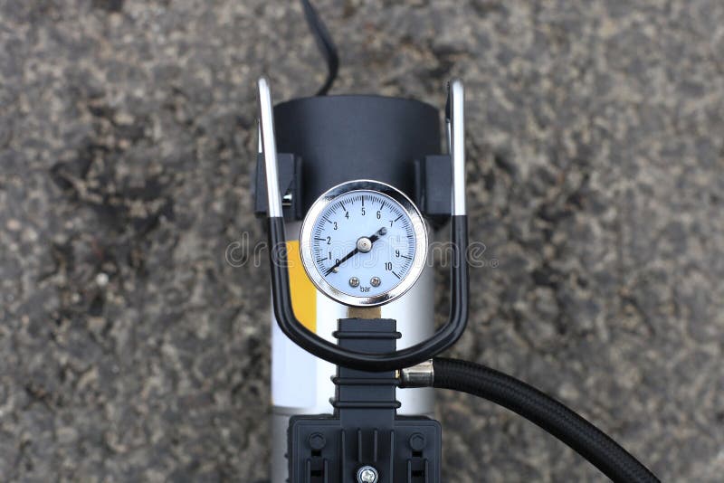 Tire inflator car tool on road. Portable metal air compressor pump for car wheels, driver equipment