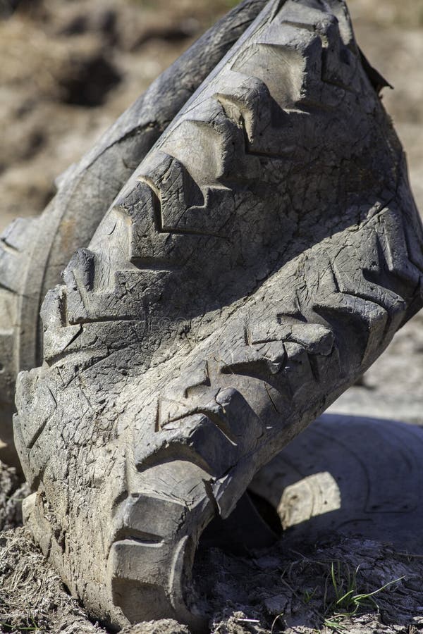 Tire rubber pollution. Old deformed tractor tyre posing a threat royalty free stock photo Tire rubber pollution. Old deformed tractor tyre posing a threat royalty free stock photo