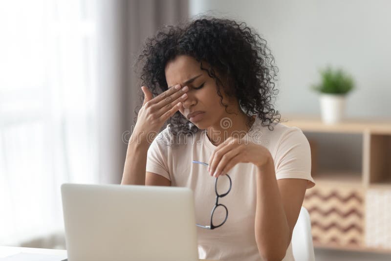 Tired African American woman taking off glasses, feeling eye strain