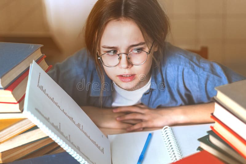 Tired bored teen girl upset by difficult learning.