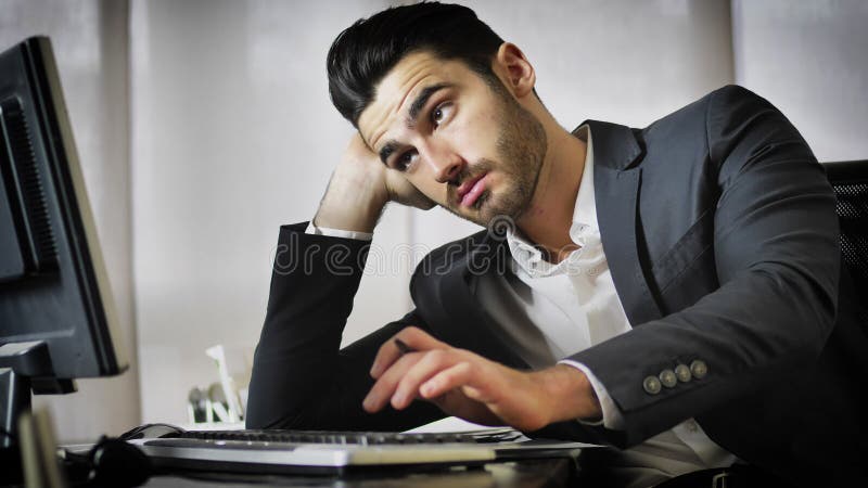 Tired bored young businessman in office stock image Tired bored young businessman in office stock image