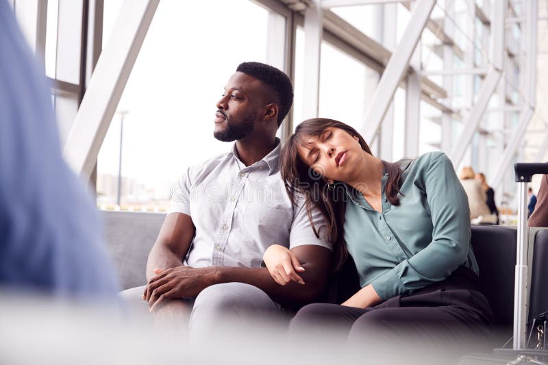 Tired Business Couple Sitting By Window Waiting In Airport Departure Lounge stock photos Tired Business Couple Sitting By Window Waiting In Airport Departure Lounge stock photos