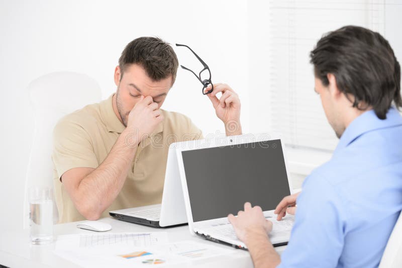 Tired businessman. Two business people sitting at their working royalty free stock photo Tired businessman. Two business people sitting at their working royalty free stock photo