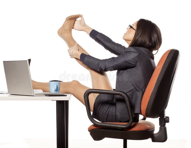 Businesswoman with legs on the table massaging her foot. Businesswoman with legs on the table massaging her foot