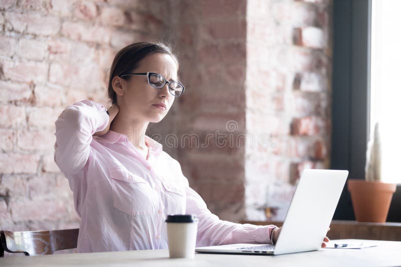 Tired businesswoman massaging strained neck muscles at workplace royalty free stock photography