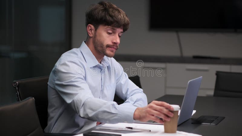 Weary Caucasian Man Sips Coffee and Works with Papers in Office stock video