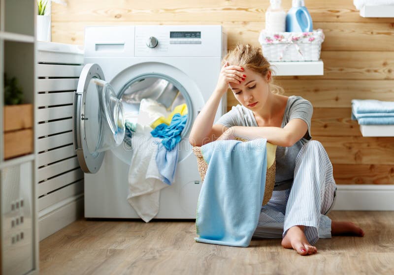 Tired housewife woman in stress sleeps in laundry room with washing machine royalty free stock image Tired housewife woman in stress sleeps in laundry room with washing machine royalty free stock image