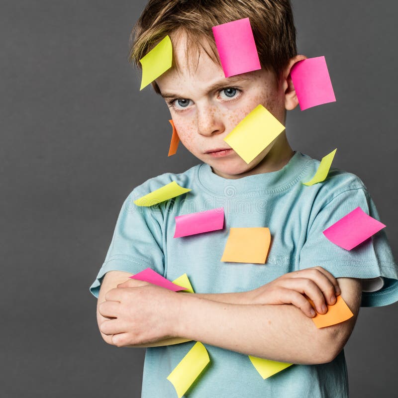 Tired kid sulking with crossed arms with notes on face