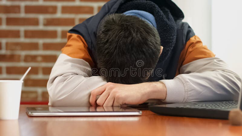 Tired male teenager sleeping on desk, laptop and tablet on table, boring work royalty free stock photography Tired male teenager sleeping on desk, laptop and tablet on table, boring work royalty free stock photography