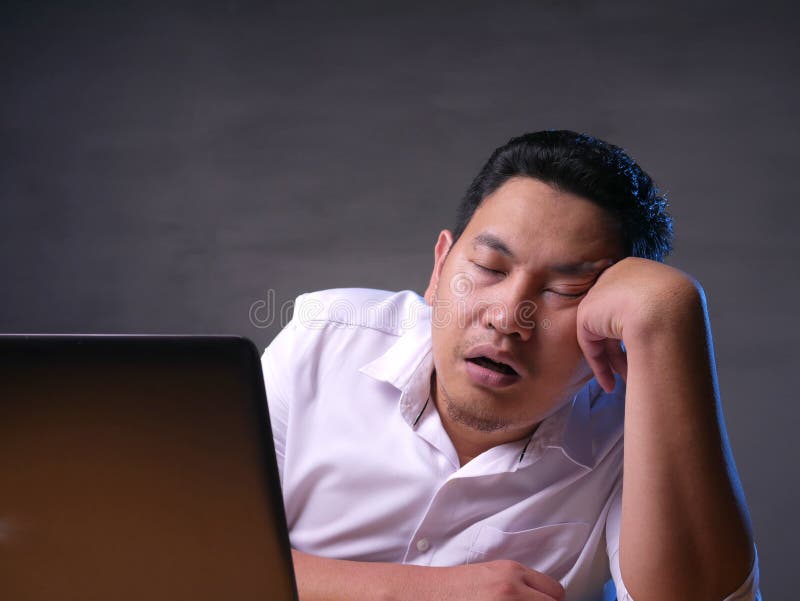 Portrait of Asian businessman tired for overworked and sleep in front of his laptop and paperworks at the office, japanese, indonesian, malaysian, thai, computer, young, job, worker, person, exhausted, sitting, people, bored, fatigue, workplace, sleeping, sleepy, break, lazy, professional, lifestyle, desk, resting, female, casual, occupation, employee, asleep, freelance, table, entrepreneur, desktop, lack, disorder, drowsiness, pause, energy, sleepiness, boredom, napping. Portrait of Asian businessman tired for overworked and sleep in front of his laptop and paperworks at the office, japanese, indonesian, malaysian, thai, computer, young, job, worker, person, exhausted, sitting, people, bored, fatigue, workplace, sleeping, sleepy, break, lazy, professional, lifestyle, desk, resting, female, casual, occupation, employee, asleep, freelance, table, entrepreneur, desktop, lack, disorder, drowsiness, pause, energy, sleepiness, boredom, napping