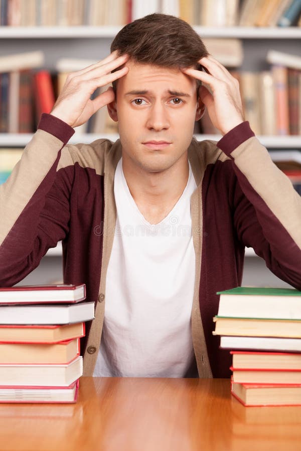 человек в растерянности смотрит на стопку книг