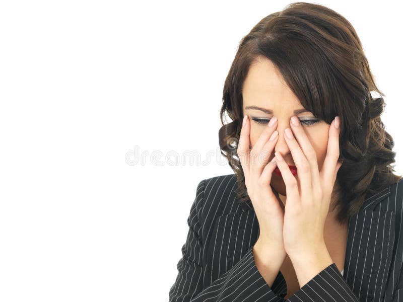 A DSLR royalty free image, young business woman, with dark hair, looking mortified upset stressed upset with hands placed on face shocked with eyes looking down, wearing dark jacket, against white background. A DSLR royalty free image, young business woman, with dark hair, looking mortified upset stressed upset with hands placed on face shocked with eyes looking down, wearing dark jacket, against white background.