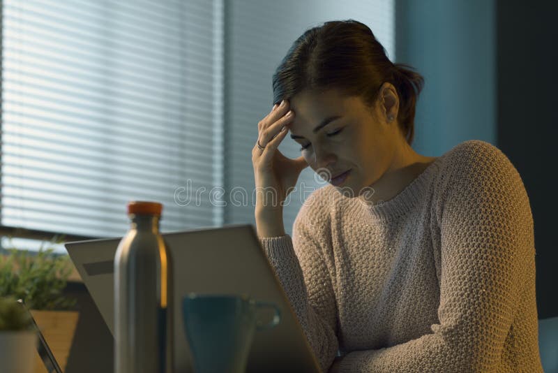 Tired woman with headache working with a laptop royalty free stock image