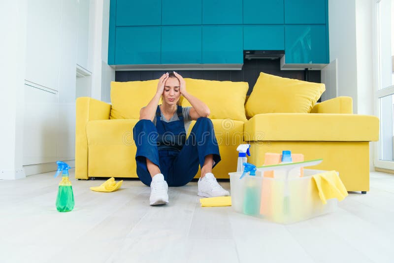 Premium Photo  Tired housewife with cleaning tools is sitting on