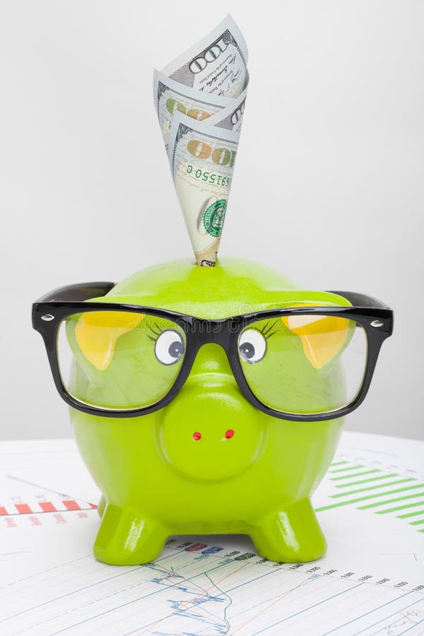 Tirelire verte au-dessus de diagramme de marché boursier avec 100 dollars de billet de banque image stock